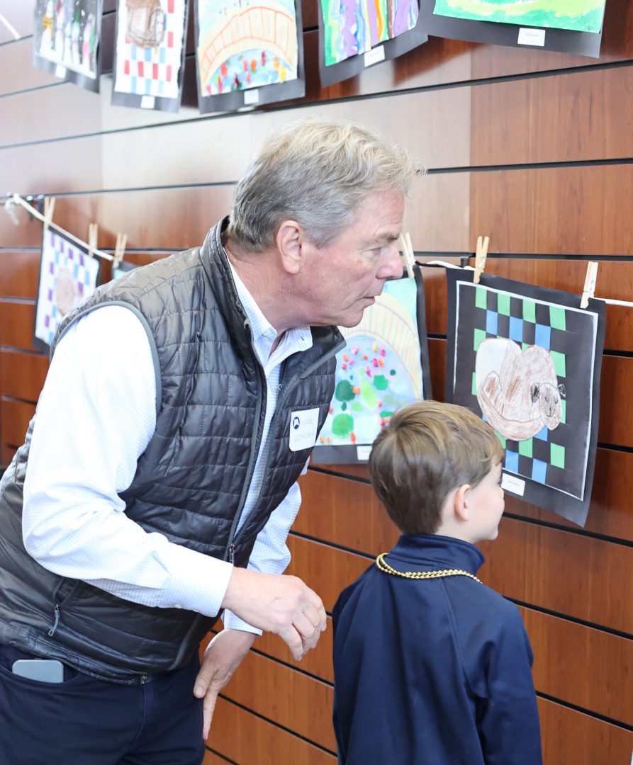 Grandchildren and grandparents view the students' works of art.